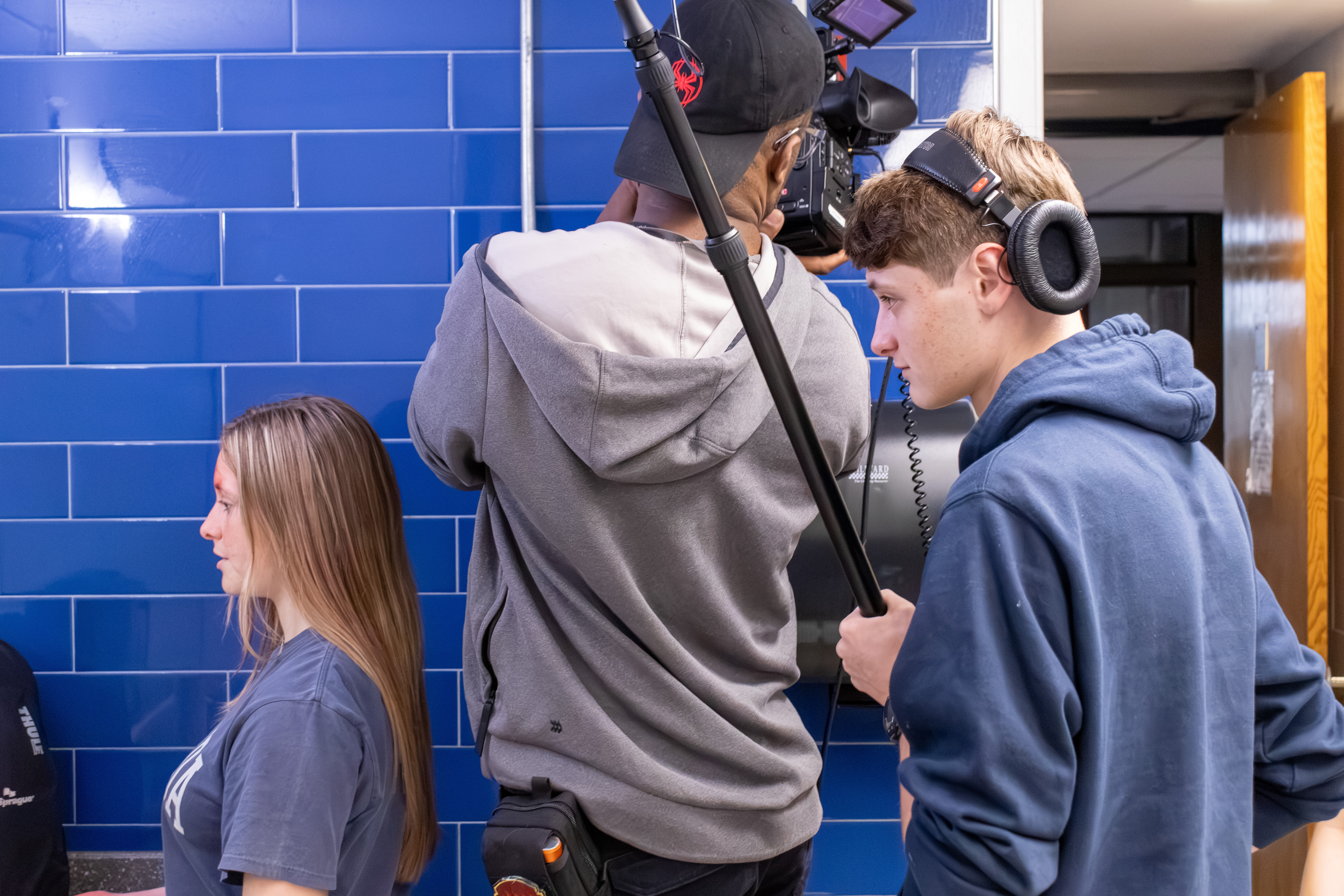 A student booms a scene beside the DP operating the camera on set