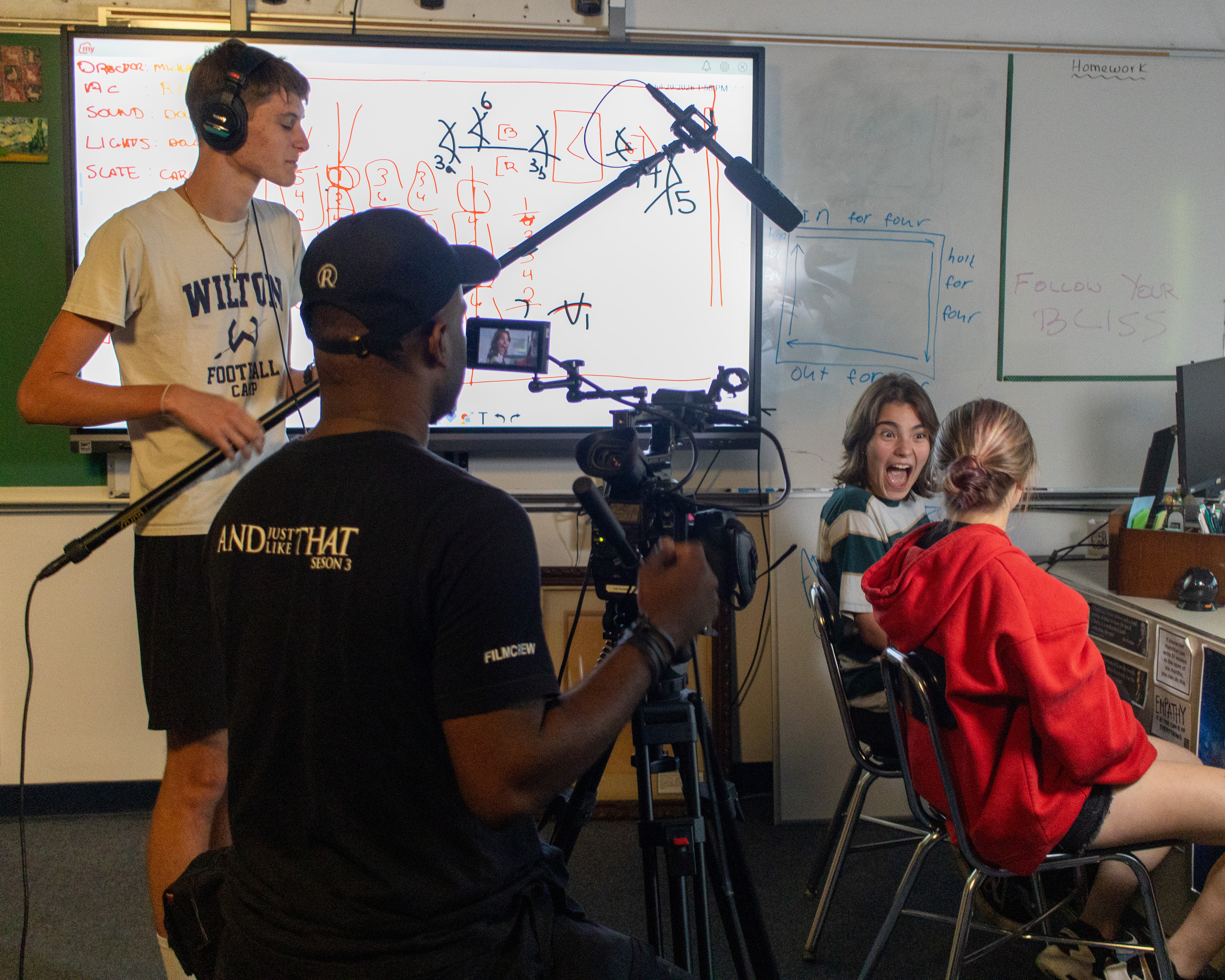 A student film crew shooting a scene in a classroom