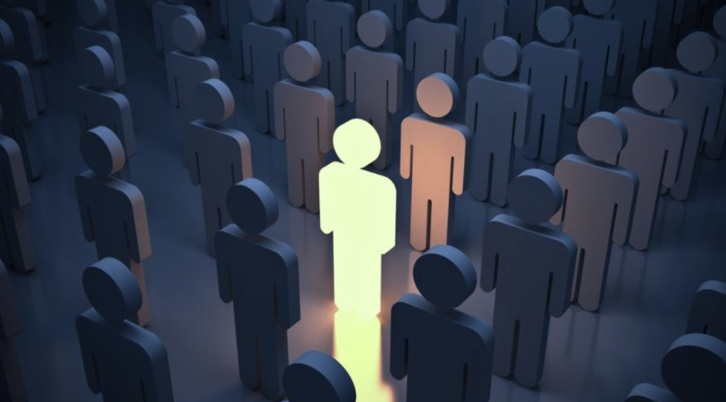 One glowing figure standing out amid a crowd of identical dark figures — being the change