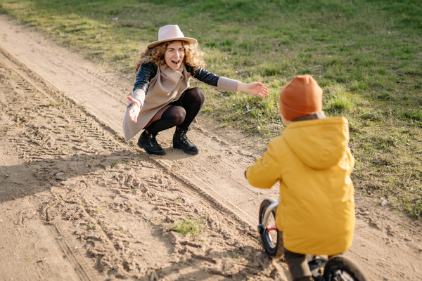 Mum encouraging child on bike