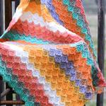 multicolored blanket draped over a wooden chair