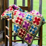 multicolored afghan draped on a wooden chair