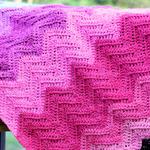 wavy blanket in shades of pink on railing