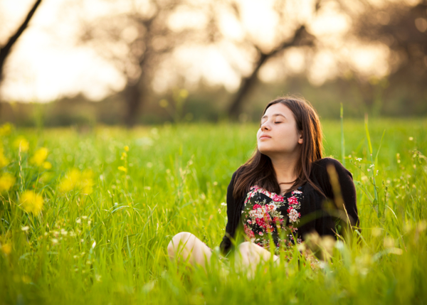 Woman sitting in a field of flowers free of her anxiety
