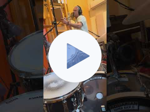 Video of a man singing at a microphone in a recording studio