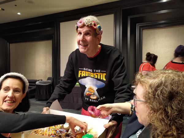 The wonderful Scott Edelman, serving up colorful donuts while wearing a 3D donut crown and an Eating the Fantastic shirt