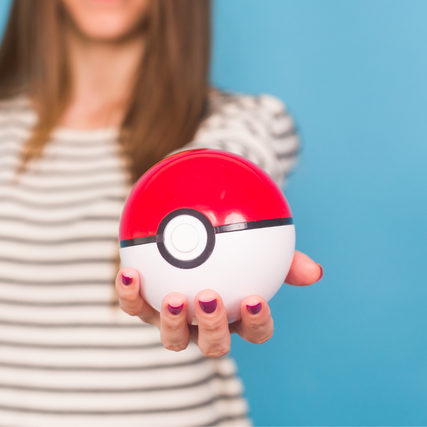 A woman holding out a Poké Ball towards the viewer.