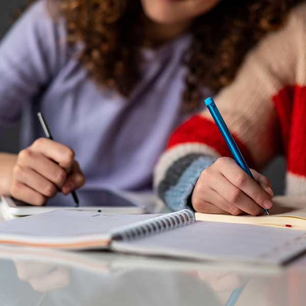 People writing in a notebook.