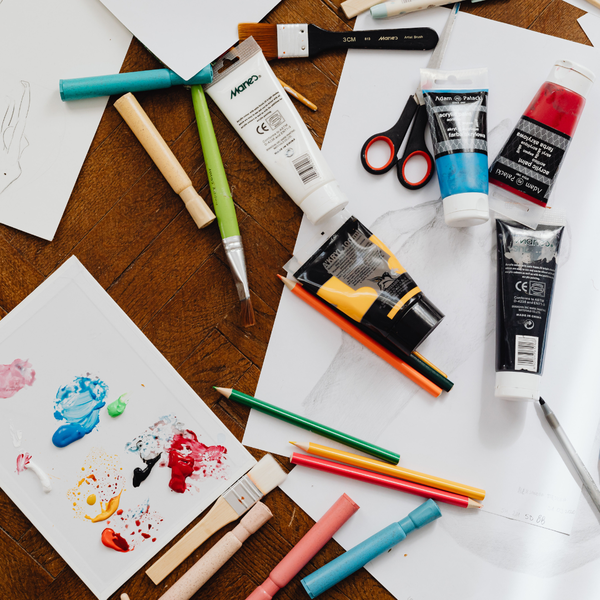 Art supplies and paper scattered across a table.