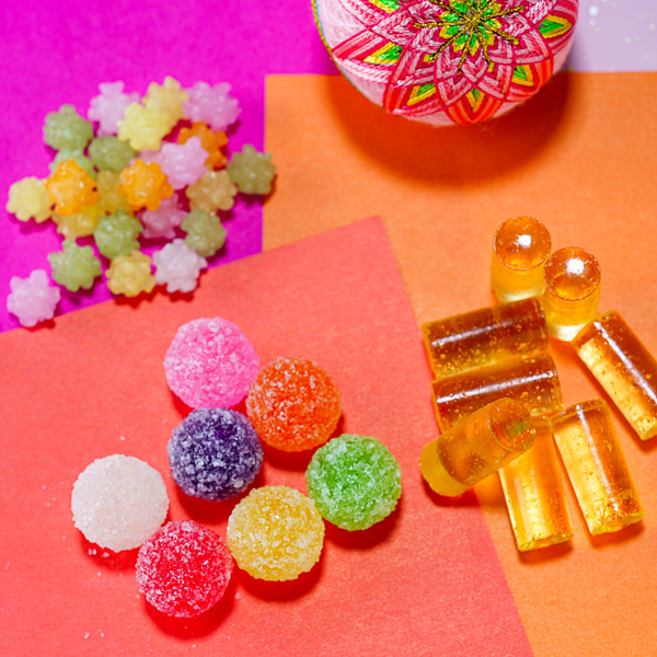Various candies are on bright colored paper.