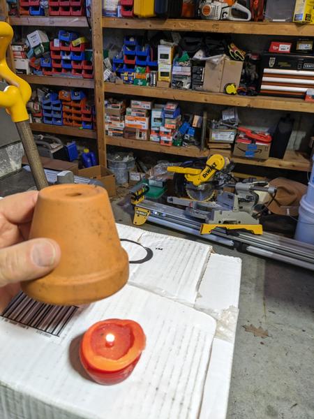 clay pot and lit candle in garage