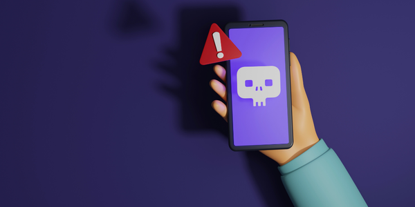 A hand holding a mobile device with a red warning triangle symbol next to it.