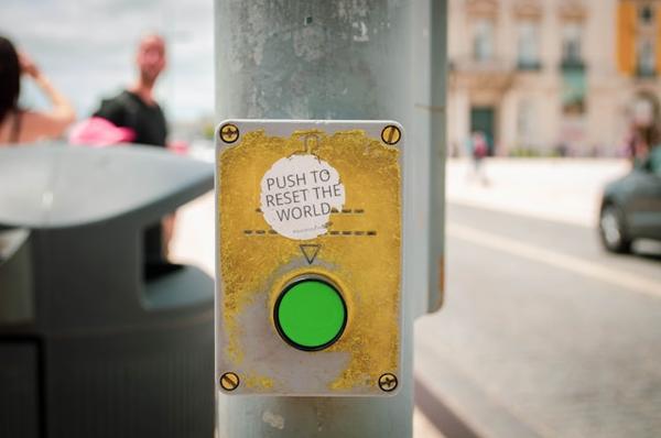 Green button with text above saying 'push to reset the world'