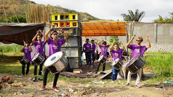Group of musicians with samba drums wearing purple T Shirts