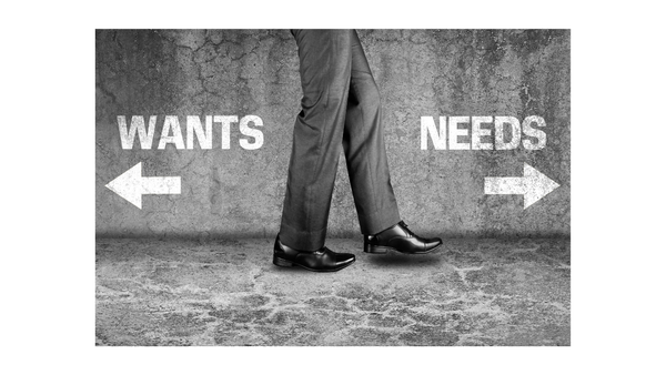person wearing grey trousers walking towards the word 'needs' and away from the word 'wants'