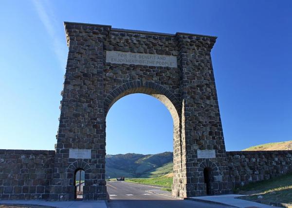 Large stone arch with blue sky in background.