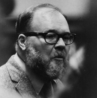 Portrait of a man with a beard and wearing glasses.