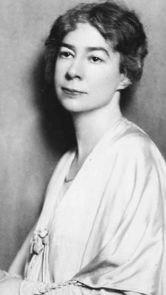 A black-and-white portrait of a woman in a white gown, with short, dark hair and sad eyes.