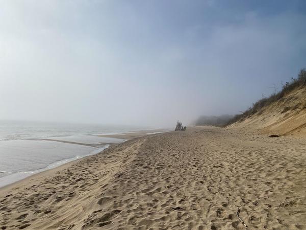 A fort-like structure appears quietly in the distance, surrounded by the morning mist on a beautiful Cape Cod beach. The sea to the left, the cliff dunes to the right, one is enveloped in mystery and beauty. 