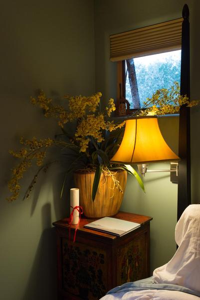 A quiet bedroom corner, yellow forsythia flowers in a basket, scroll, book, warm yellow lamplight