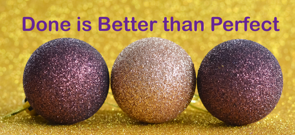 Three purple sparkly holiday ball decorations laying on gold sparkle with words Done is Better than Perfect written above them