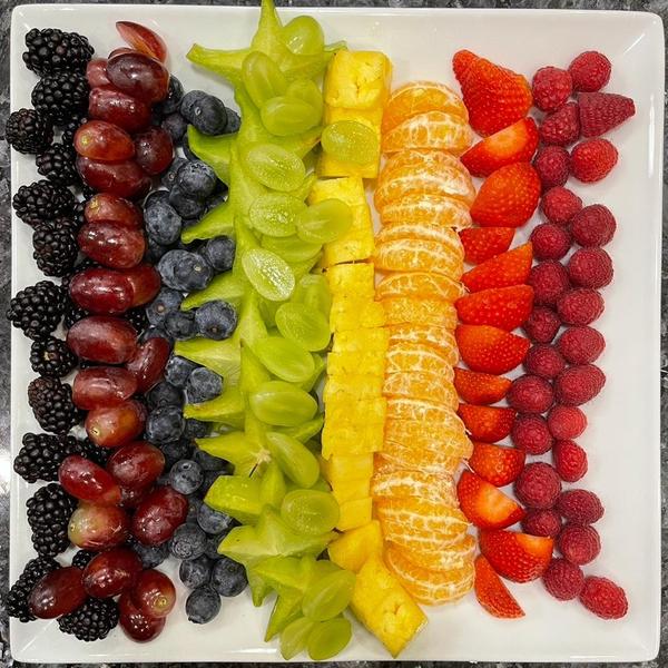 Colorful fruit tray of blackberries, grapes, blueberries, kiwi, tangerines, strawberries and raspberries for act happy week day 4 agility