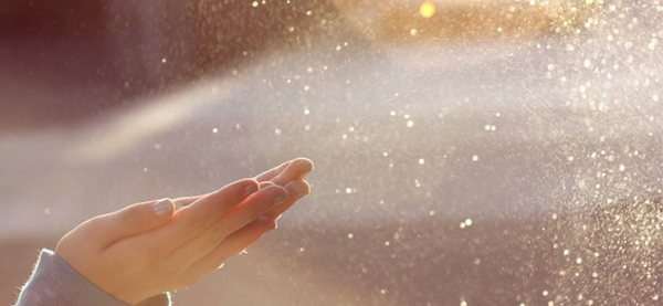 Hands reaching out to catch dust motes