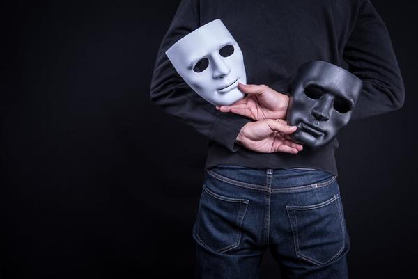 Hands holding theatrical masks
