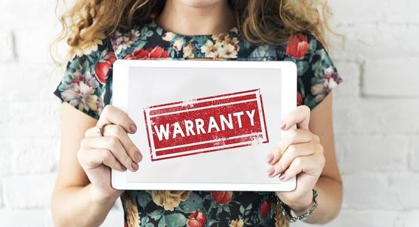 A person holding a sign that says 'warranty'