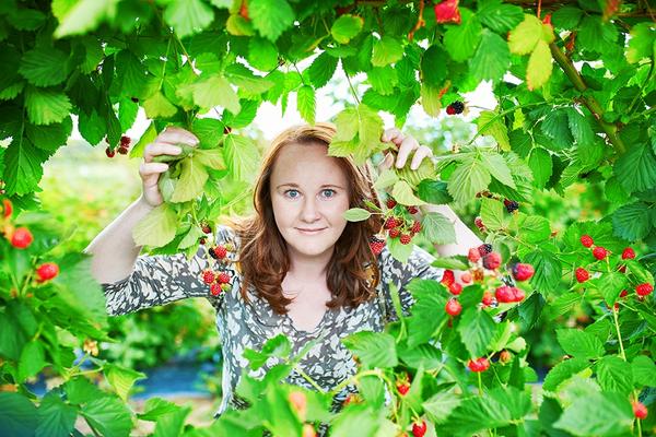 A woman looking through a blackberry bush