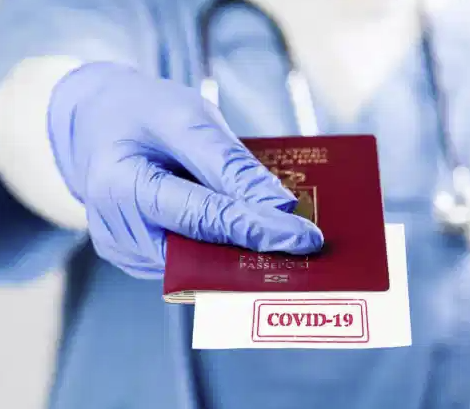 A gloved hand with a Covid stamped passport