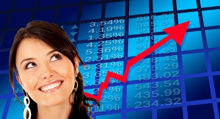 A woman in front of a stock board