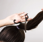 Scissors cutting a ponytail