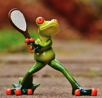 A frog statue holding a tennis raquet