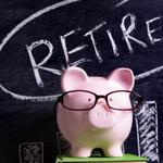 A piggy bank in front of a blackboard that says Retire