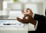 Hands at a desk with a zen sign