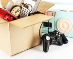 A cardboard box with an old Playstation controller and other things