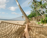 Feet in a hammock on a beach