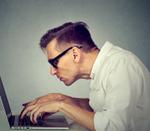 A freelancer hunches over his laptop