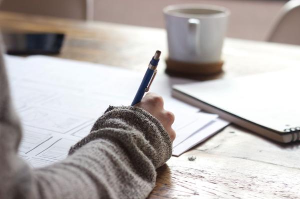 person writing with a pen