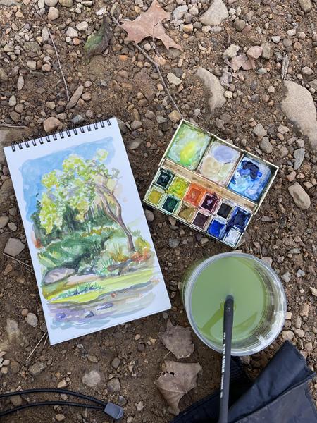 Watercolor Sketch of the Eno with watercolor set and paintbrush and water on stones.