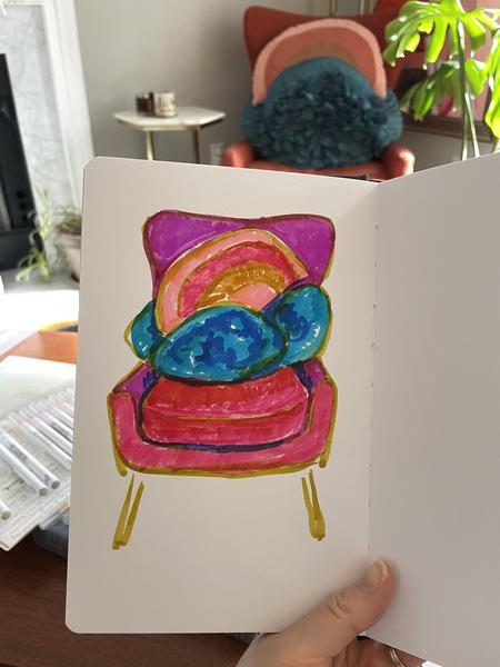 Watercolor marker sketch of her mid-century pink chair with vibrant colored pillows