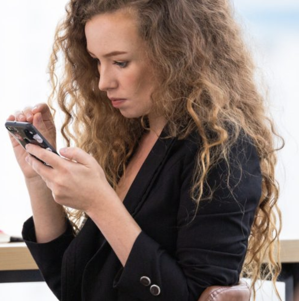 Businesswoman using mobile phone reading message or social network