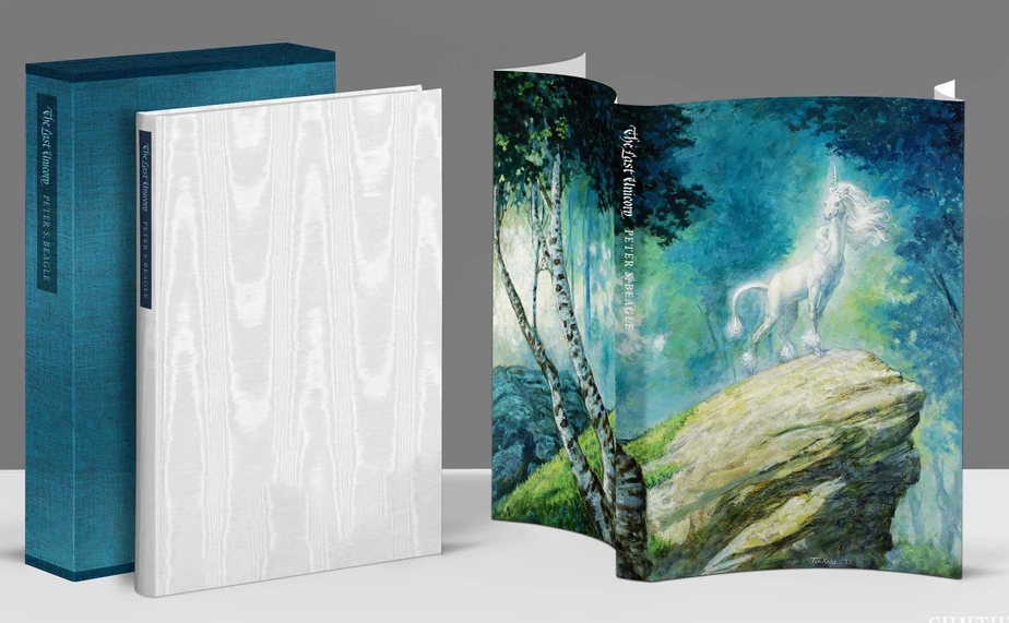 The Last Unicorn Classic Edition from Suntup Editions: white moiré cloth binding with a dark spine label, a teal cloth slipcase, and a wraparound dust jacket painted with a white unicorn on a mossy rock in a misty forest