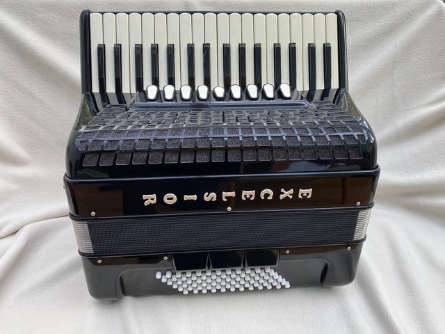 An accordion on a white surface
            
            Description automatically generated