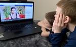Two boys watching storytelling on computer