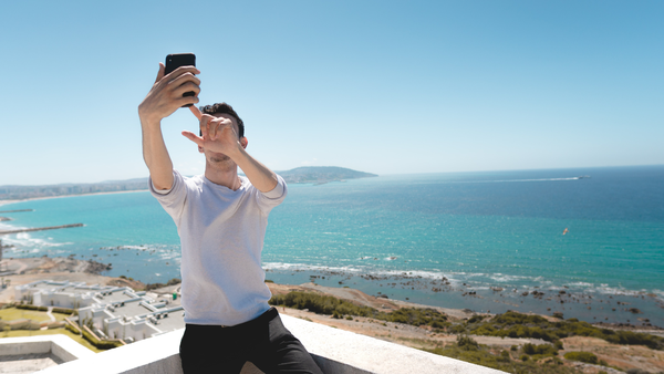 man taking selfie near ocean