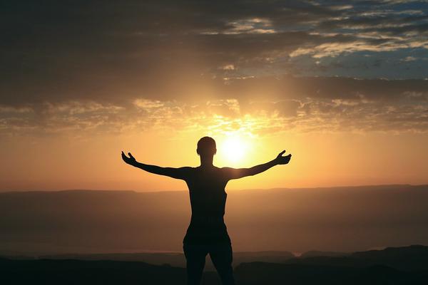 Silhouette of woman in front of sunset