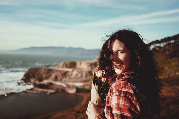 Smiling Woman with Roses by the Ocean