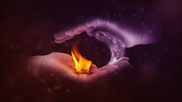 Two hands holding yin yang fire and water